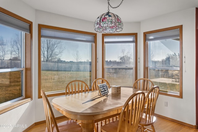 dining area featuring baseboards, plenty of natural light, and light wood-style floors