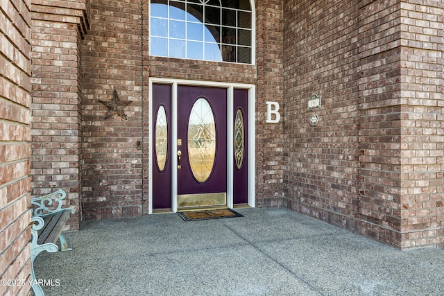 entrance to property featuring brick siding