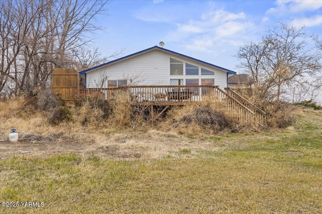 rear view of house with a deck and a yard