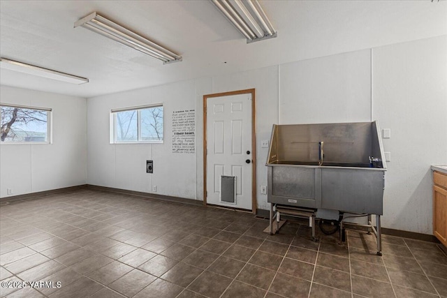 misc room featuring dark tile patterned flooring and baseboards