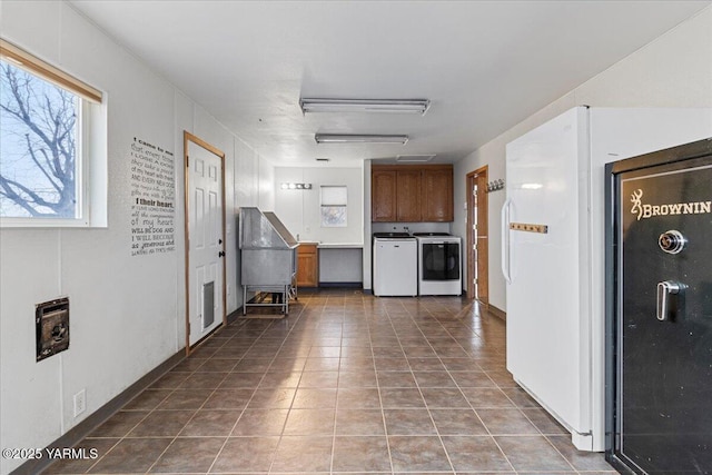 corridor featuring washing machine and dryer and dark tile patterned flooring