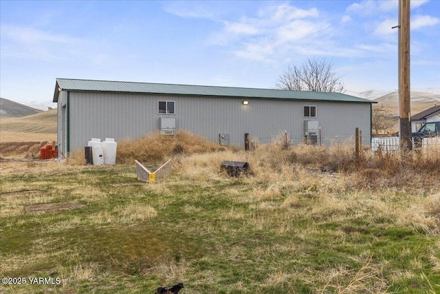 exterior space with a mountain view, metal roof, and an outbuilding