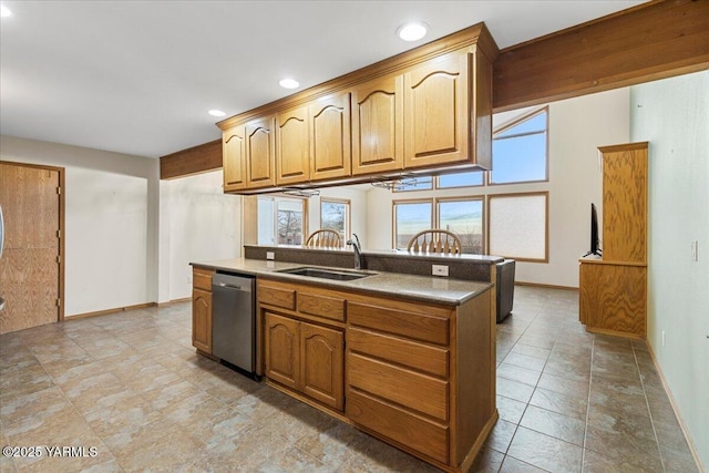 kitchen with baseboards, stainless steel dishwasher, a sink, and brown cabinets