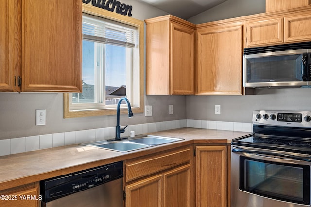 kitchen with light countertops, stainless steel appliances, a sink, and lofted ceiling