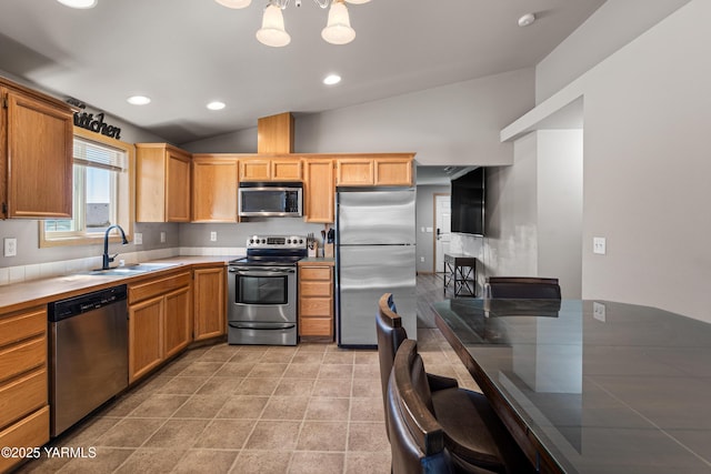 kitchen featuring lofted ceiling, recessed lighting, tile countertops, a sink, and appliances with stainless steel finishes