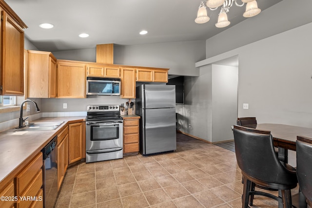 kitchen with light countertops, a sink, vaulted ceiling, and stainless steel appliances