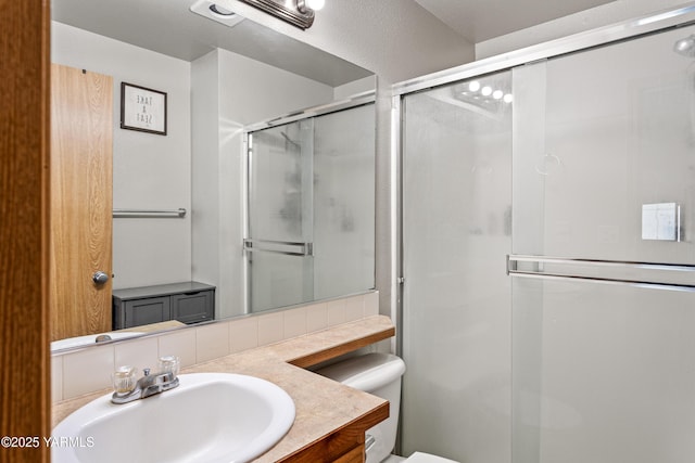 full bath featuring vanity, a stall shower, and toilet