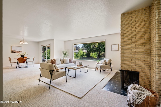 carpeted living room with a brick fireplace, baseboards, and a textured ceiling