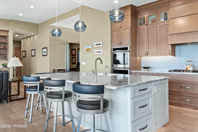 5506 Marilane St, Yakima, WA 98908 - kitchen with appliances with stainless steel finishes, premium range hood, light wood-style floors, tasteful backsplash, and recessed lighting