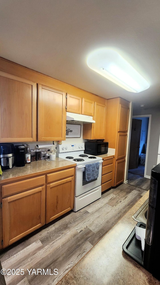 6402 Crestfields Rd, Yakima, WA 98908 - kitchen featuring electric stove, black microwave, under cabinet range hood, and light wood-style floors