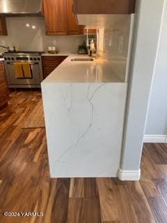 kitchen with brown cabinets, under cabinet range hood, stainless steel range, and light countertops