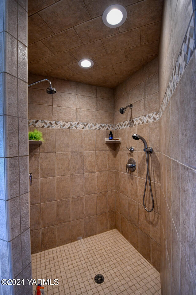 bathroom with tiled shower and recessed lighting