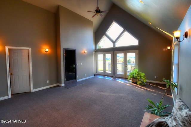 unfurnished living room with high vaulted ceiling, carpet flooring, baseboards, and a ceiling fan