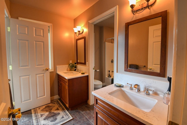 bathroom with toilet, two vanities, and a sink