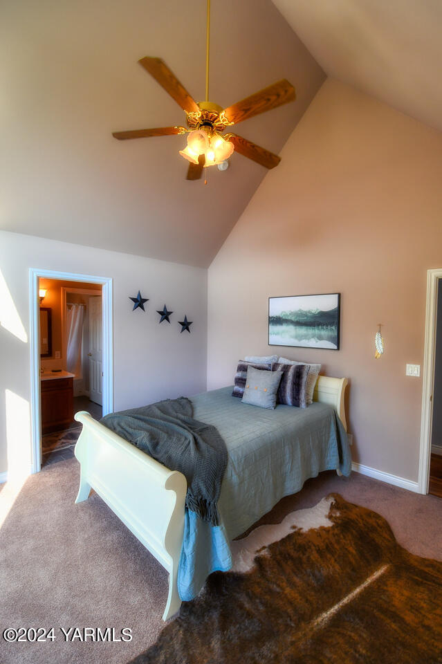 bedroom with a ceiling fan, baseboards, high vaulted ceiling, and carpet flooring