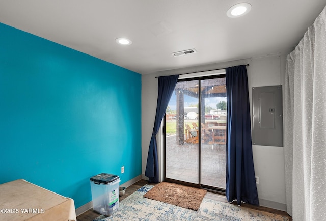 doorway featuring electric panel, wood finished floors, baseboards, and recessed lighting