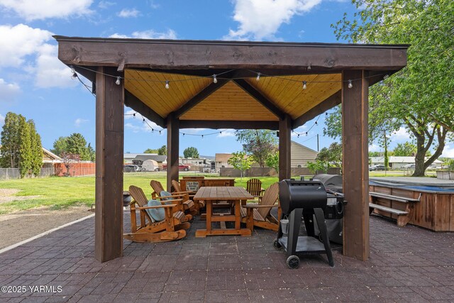 view of patio with a gazebo, a hot tub, and outdoor dining area