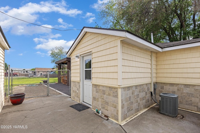 view of outbuilding featuring a gate and central air condition unit