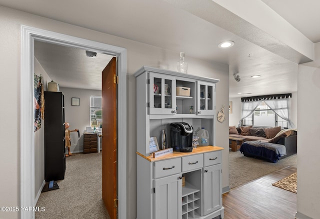 hall featuring plenty of natural light, light colored carpet, light wood-type flooring, and recessed lighting