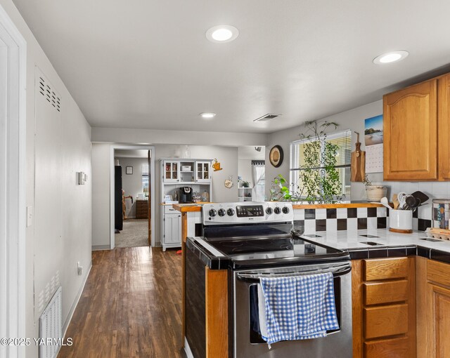 kitchen with electric range, dark wood-type flooring, healthy amount of natural light, recessed lighting, and a peninsula