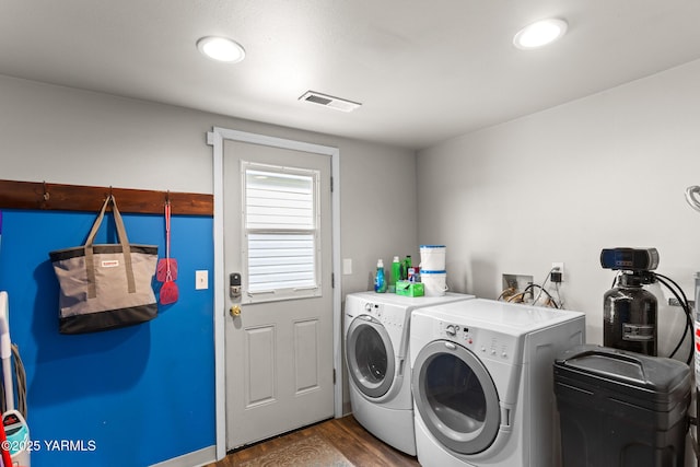 clothes washing area featuring washing machine and clothes dryer, wood finished floors, and recessed lighting
