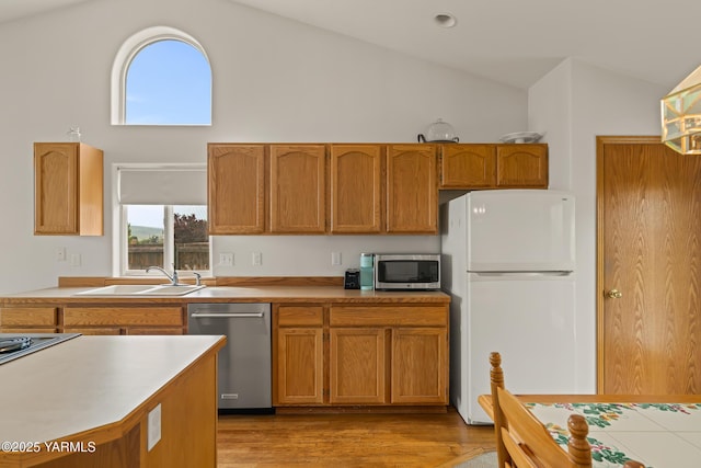 2 N 74th Ave, Yakima, WA 98908 - kitchen with appliances with stainless steel finishes, high vaulted ceiling, a sink, light countertops, and light wood-style flooring