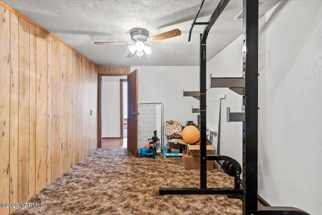 101 W Slavin Rd, Yakima, WA 98903 - exercise room with wooden walls, a ceiling fan, a textured ceiling, and carpet floors