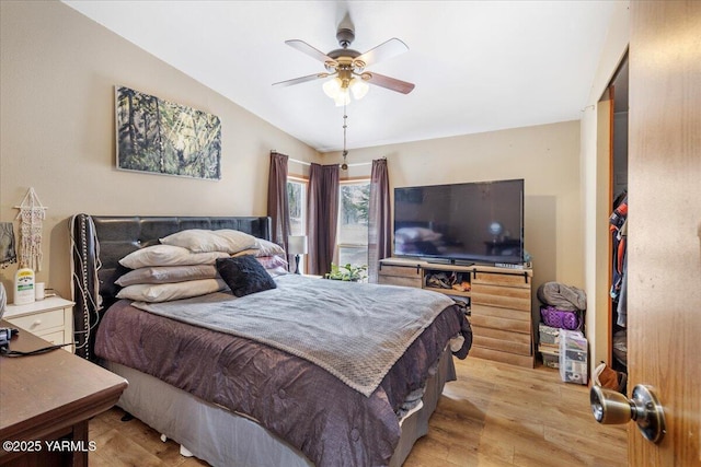 bedroom with lofted ceiling, ceiling fan, and light wood-type flooring