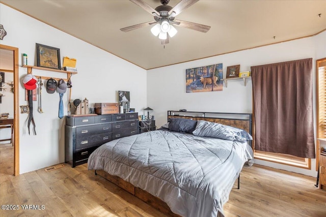 bedroom with lofted ceiling, ceiling fan, visible vents, and wood finished floors