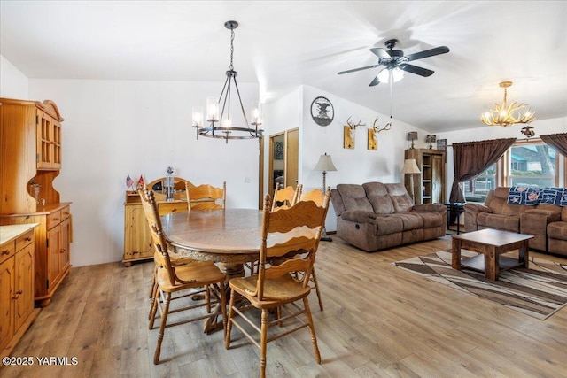 dining space with light wood-type flooring and ceiling fan with notable chandelier