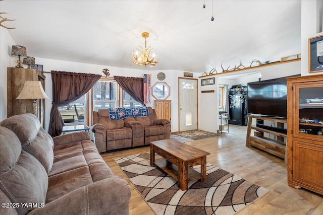 living area with light wood-style floors and a notable chandelier