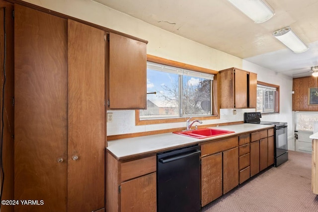 kitchen featuring black appliances, a sink, light countertops, and brown cabinets