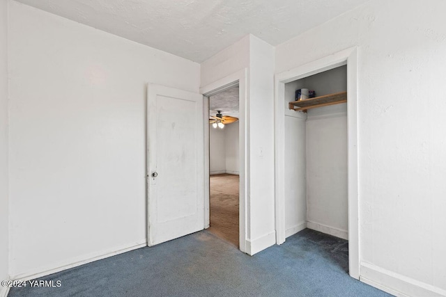 unfurnished bedroom featuring a closet and dark carpet