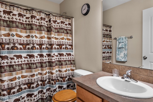 full bathroom with tasteful backsplash, curtained shower, toilet, and vanity