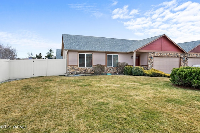 view of front of home with fence, roof with shingles, an attached garage, a front lawn, and stone siding