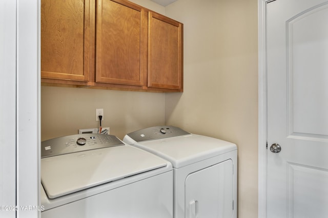 laundry room featuring washing machine and clothes dryer and cabinet space