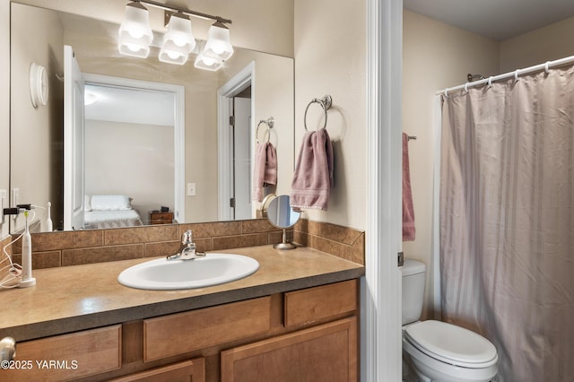 ensuite bathroom featuring ensuite bathroom, toilet, and vanity