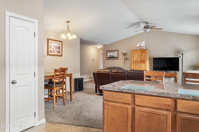 kitchen with open floor plan, light colored carpet, ceiling fan with notable chandelier, and vaulted ceiling