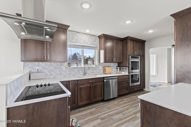 419 N 62nd Ave, Yakima, WA 98908 - kitchen featuring a sink, island range hood, decorative backsplash, dark brown cabinetry, and appliances with stainless steel finishes