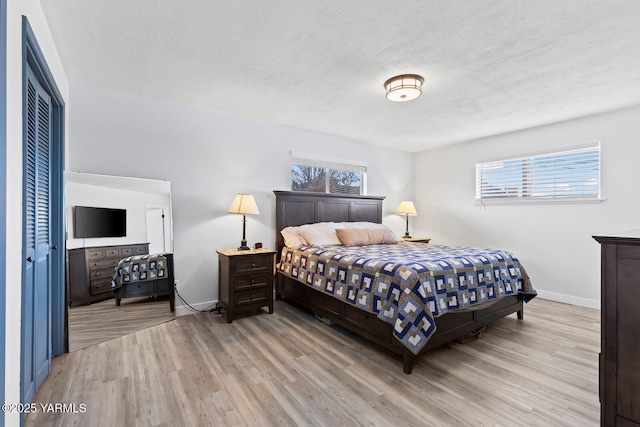 419 N 62nd Ave, Yakima, WA 98908 - bedroom with light wood-style floors, a textured ceiling, baseboards, and multiple windows