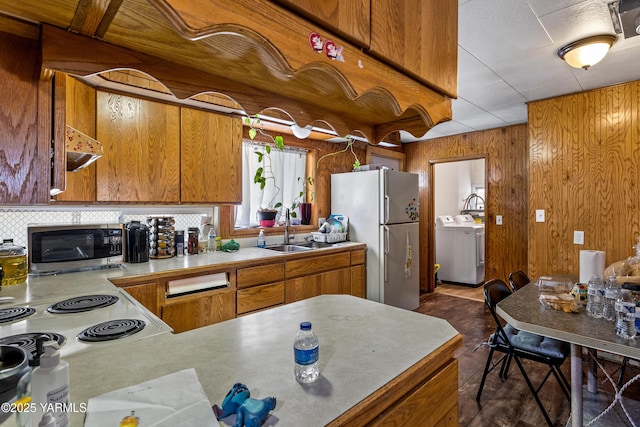 1523 Roosevelt Ave, Yakima, WA 98902 - kitchen featuring freestanding refrigerator, stainless steel microwave, a sink, brown cabinetry, and washer and clothes dryer