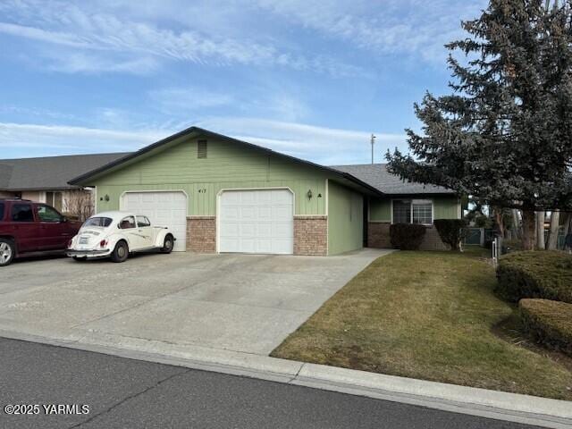 ranch-style house with a garage, concrete driveway, brick siding, and a front lawn