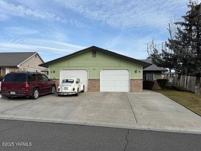 single story home with a garage and brick siding