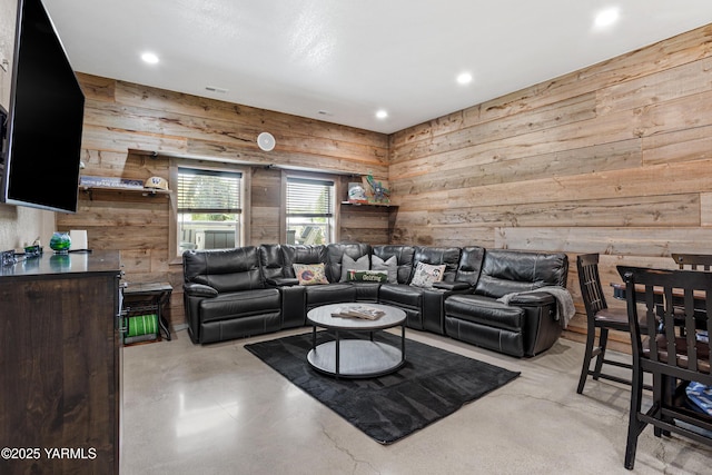 living area with recessed lighting, wood walls, and finished concrete flooring