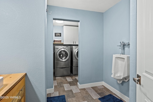 laundry area with baseboards, cabinet space, washing machine and dryer, and wood finished floors