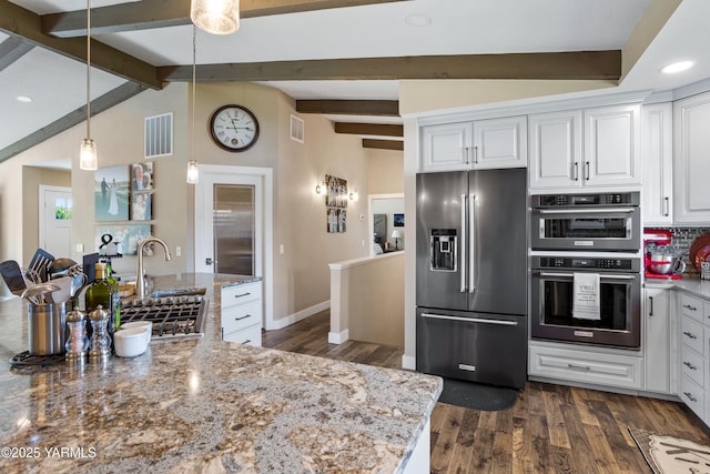 kitchen featuring visible vents, stainless steel fridge, tasteful backsplash, a sink, and double wall oven
