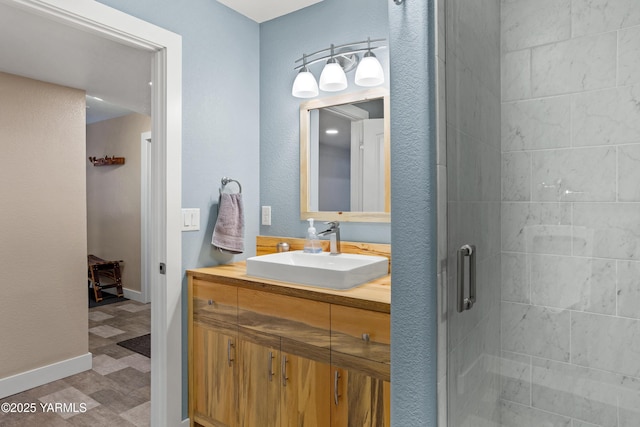 full bathroom featuring vanity, baseboards, a shower stall, and tile patterned floors