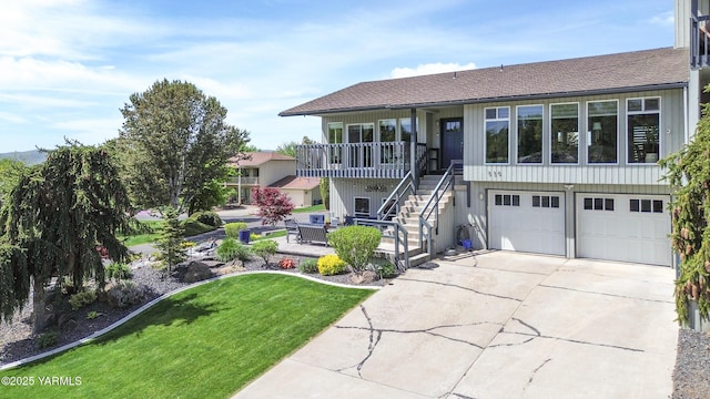 view of front of home with a front yard, concrete driveway, an attached garage, a shingled roof, and stairs