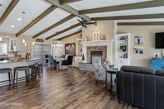 living room featuring a fireplace, ceiling fan with notable chandelier, dark wood-style floors, vaulted ceiling with beams, and recessed lighting