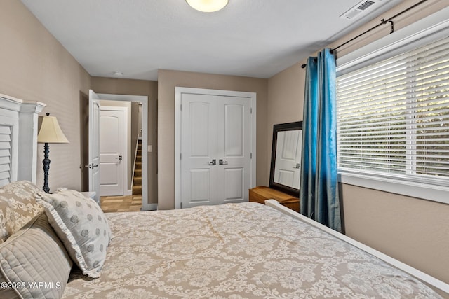 bedroom with visible vents, baseboards, and a closet